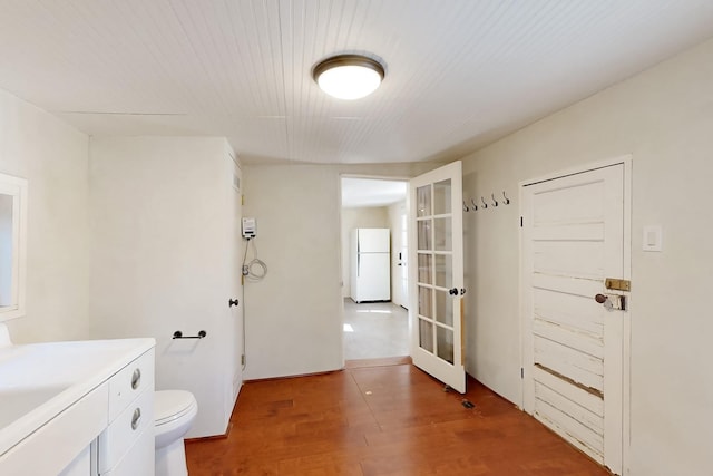 bathroom with sink, hardwood / wood-style flooring, french doors, and toilet