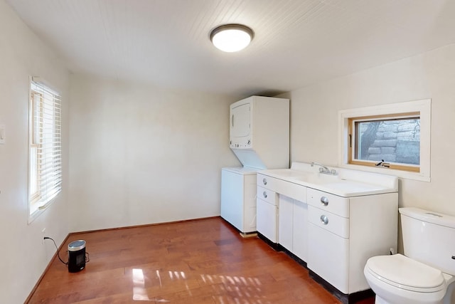 washroom featuring dark hardwood / wood-style flooring and stacked washer and clothes dryer