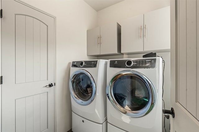 washroom featuring cabinets and washer and dryer