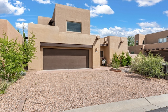 pueblo revival-style home with a garage