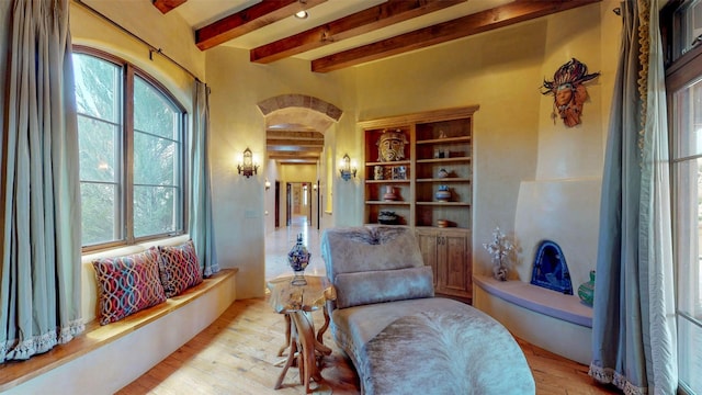 sitting room featuring beam ceiling and light hardwood / wood-style flooring