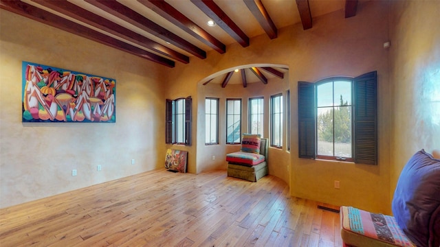 living area with light hardwood / wood-style flooring and beamed ceiling