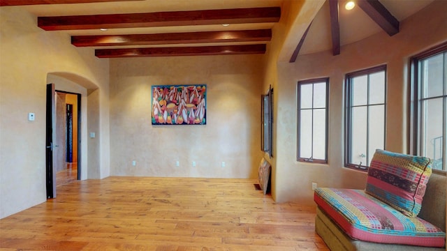 hall with beam ceiling and light wood-type flooring