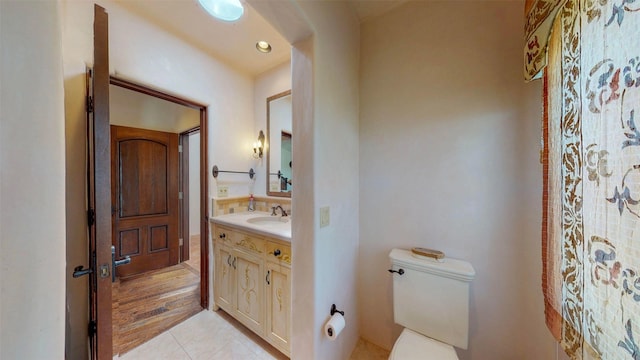 bathroom featuring vanity, tile patterned floors, and toilet