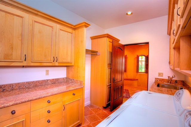 washroom featuring cabinets, washer and dryer, sink, and light tile patterned floors