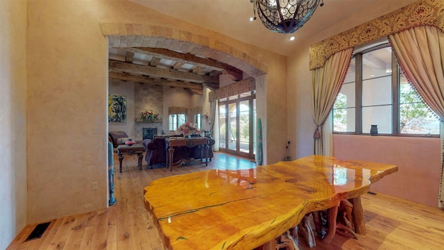 dining space with beam ceiling and light hardwood / wood-style floors