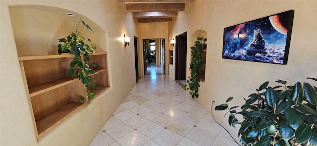 hallway featuring beamed ceiling and tile patterned floors