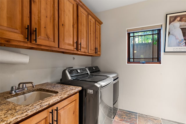 laundry area featuring cabinets, washer and clothes dryer, and sink