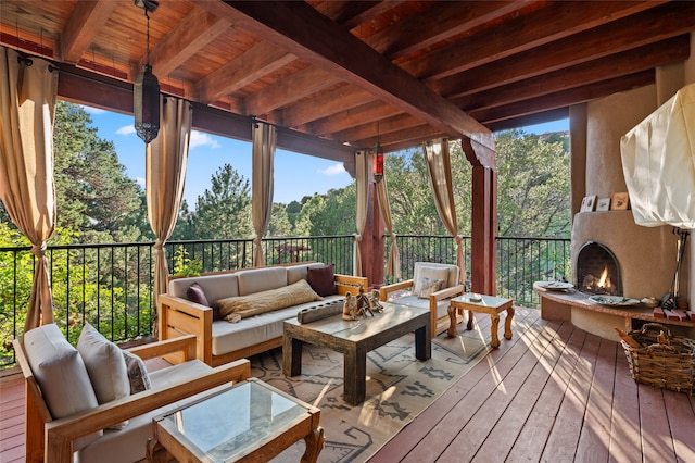 sunroom featuring exterior fireplace, beam ceiling, and a wealth of natural light