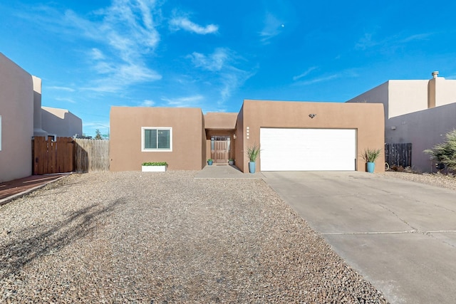 pueblo revival-style home featuring a garage