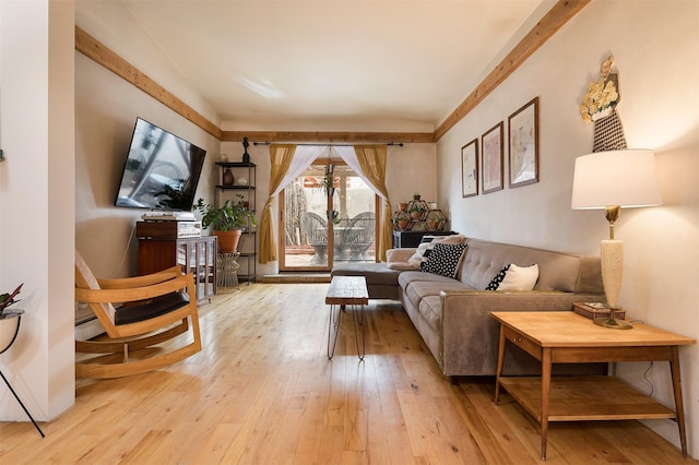 living room with baseboard heating, vaulted ceiling, and light hardwood / wood-style flooring