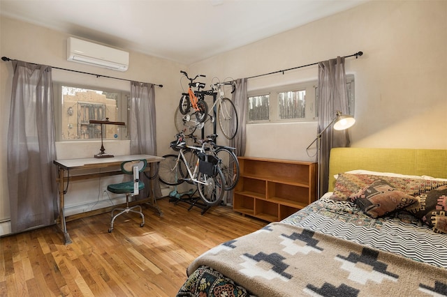 bedroom featuring wood-type flooring and a wall mounted AC