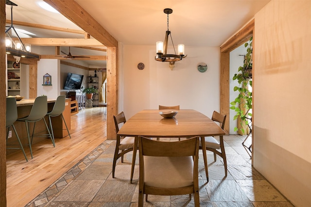 dining room with beam ceiling, a chandelier, and light wood-type flooring