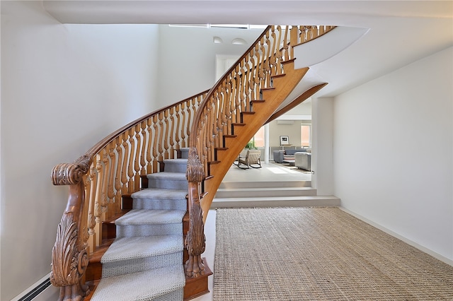 staircase featuring baseboard heating and carpet floors