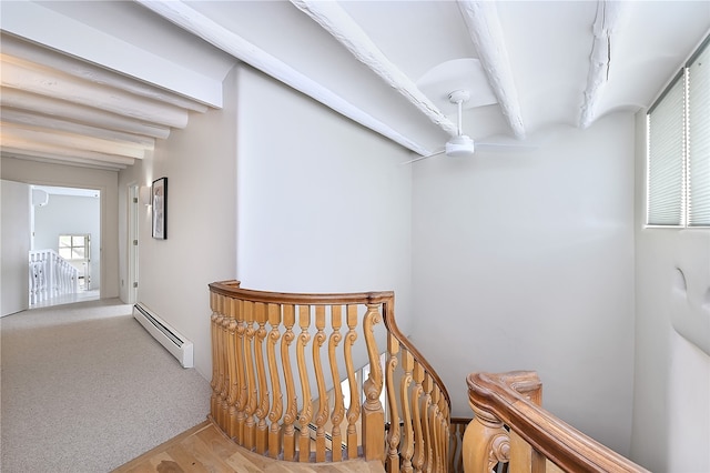 hall featuring beamed ceiling, a baseboard radiator, and carpet