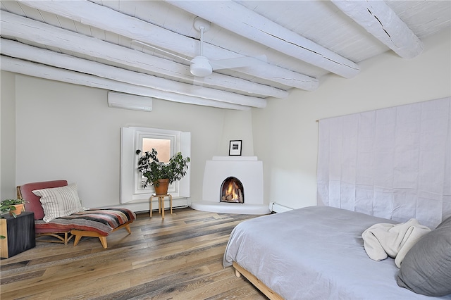 bedroom featuring wood-type flooring, an AC wall unit, beam ceiling, and baseboard heating