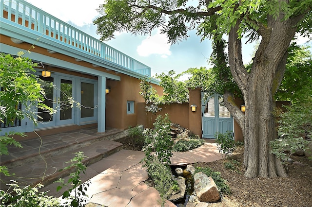 view of yard with french doors, a balcony, and a patio