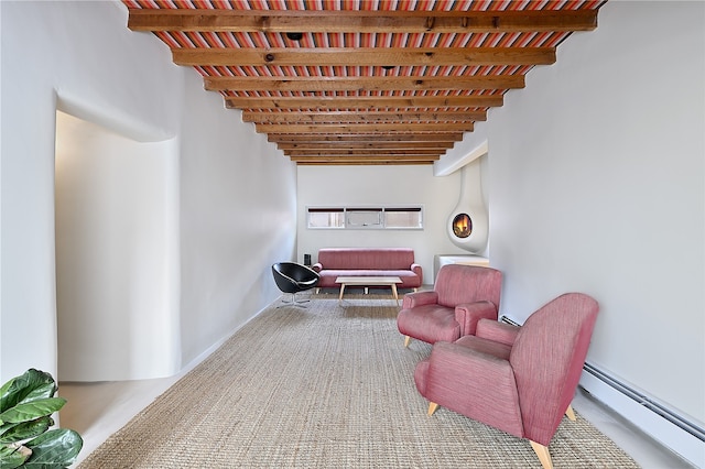 living area featuring beamed ceiling and a baseboard heating unit