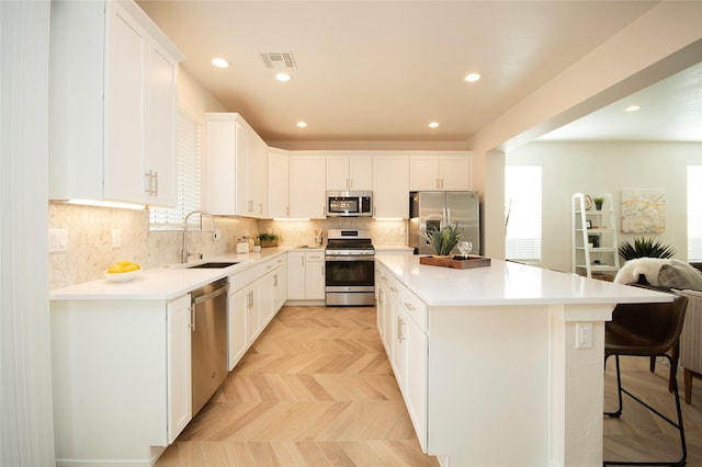 kitchen featuring stainless steel appliances, white cabinetry, and sink