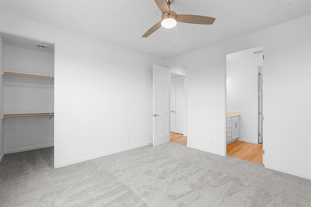 87 Cadena Loop, Los Alamos, NM 87547 - unfurnished bedroom featuring carpet floors, a spacious closet, ensuite bathroom, ceiling fan, and a closet