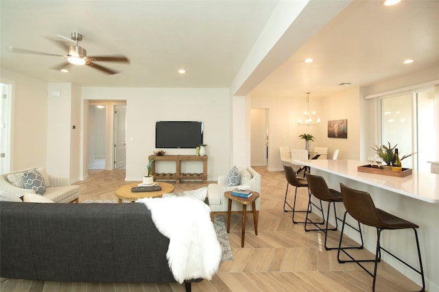 living room featuring light parquet flooring and ceiling fan with notable chandelier