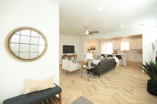 living room with ceiling fan and light parquet flooring