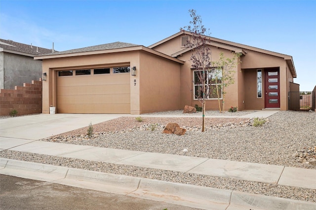 87 Cadena Loop, Los Alamos, NM 87547 - view of front of home with an attached garage, stucco siding, and concrete driveway