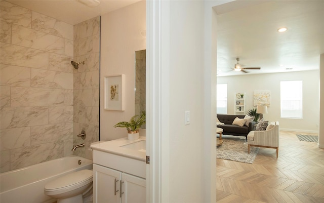 full bathroom with parquet floors, tiled shower / bath combo, vanity, ceiling fan, and toilet