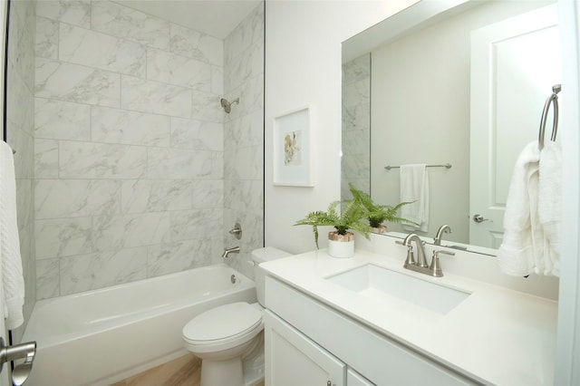 full bathroom featuring tiled shower / bath combo, vanity, and toilet