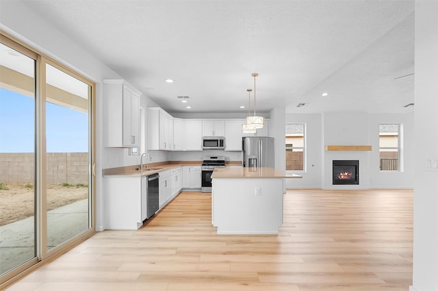 87 Cadena Loop, Los Alamos, NM 87547 - kitchen with appliances with stainless steel finishes, light wood-style flooring, recessed lighting, white cabinets, and light countertops
