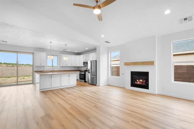 87 Cadena Loop, Los Alamos, NM 87547 - kitchen with stainless steel appliances, a ceiling fan, open floor plan, white cabinets, and light wood-style floors