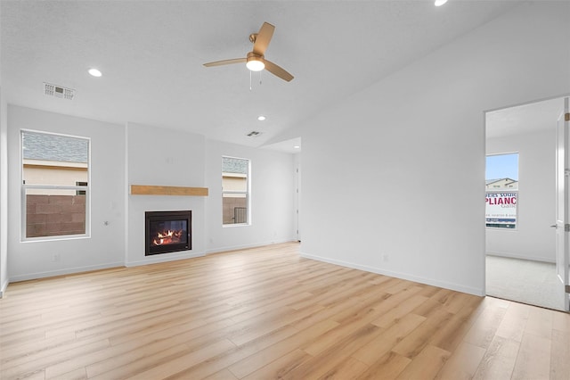 87 Cadena Loop, Los Alamos, NM 87547 - unfurnished living room with ceiling fan, light wood finished floors, recessed lighting, a glass covered fireplace, and vaulted ceiling