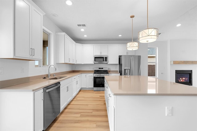 87 Cadena Loop, Los Alamos, NM 87547 - kitchen with appliances with stainless steel finishes, a kitchen island, recessed lighting, white cabinetry, and light countertops