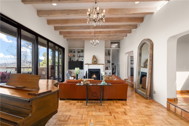 145 Brownell Howland, Santa Fe, NM 87501 - living room with a lit fireplace, arched walkways, beam ceiling, and a chandelier
