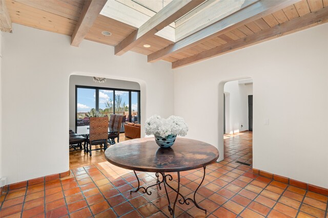 145 Brownell Howland, Santa Fe, NM 87501 - dining room featuring arched walkways, beamed ceiling, wooden ceiling, baseboards, and tile patterned floors