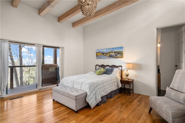 145 Brownell Howland, Santa Fe, NM 87501 - bedroom with beamed ceiling, a high ceiling, and light wood-type flooring