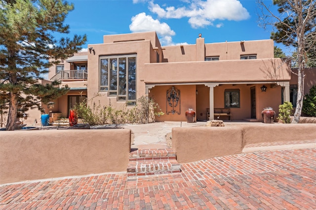 145 Brownell Howland, Santa Fe, NM 87501 - pueblo-style house featuring stucco siding and a balcony