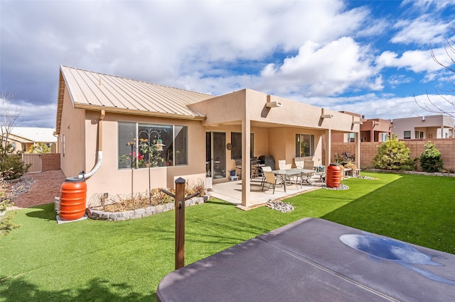 back of house featuring a lawn and a patio area