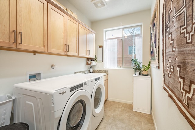 laundry room with light tile patterned floors, washer and clothes dryer, and cabinets