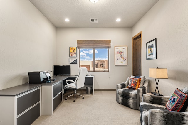 home office with a textured ceiling and light carpet