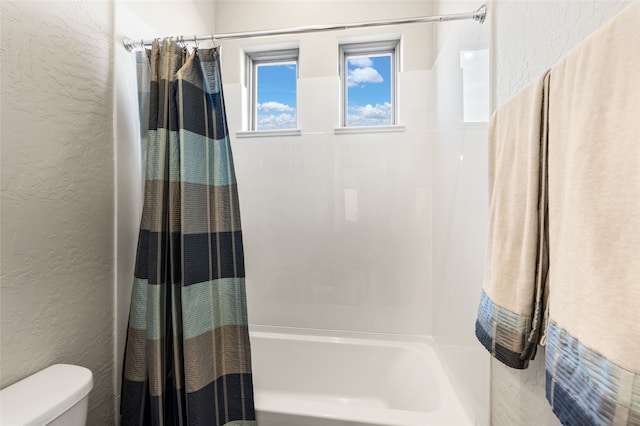 bathroom featuring shower / tub combo with curtain and toilet