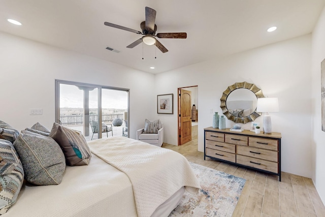 bedroom featuring ensuite bath, light hardwood / wood-style flooring, ceiling fan, and access to exterior