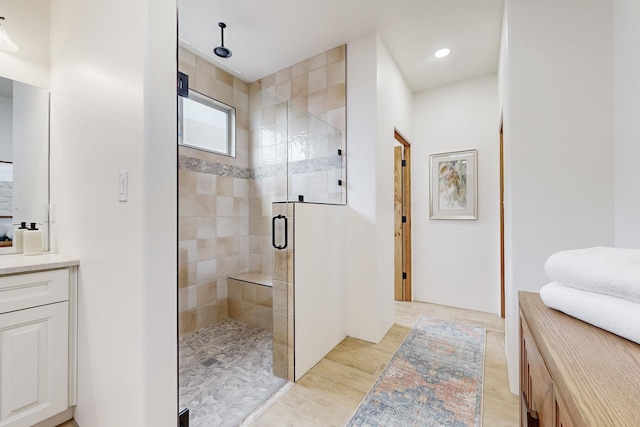 bathroom featuring vanity and a shower with door