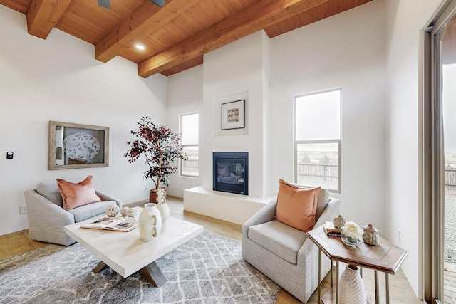 living room featuring beam ceiling, light hardwood / wood-style flooring, and wood ceiling