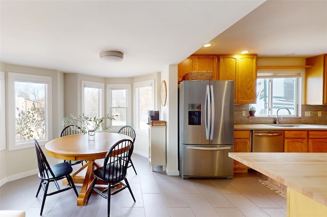 kitchen with decorative backsplash, sink, and stainless steel appliances