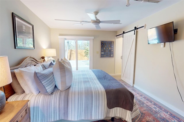 bedroom featuring access to outside, ceiling fan, and a barn door