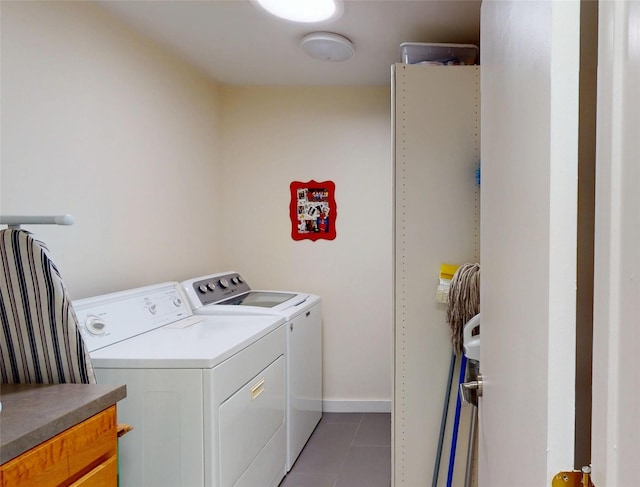 washroom featuring dark tile patterned flooring and washer and clothes dryer