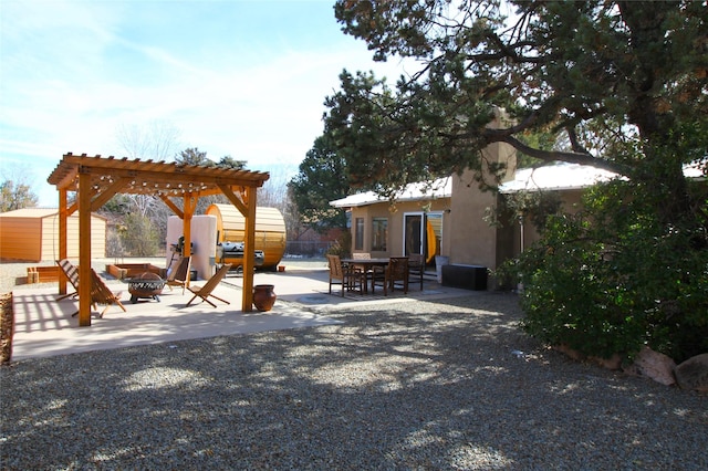 view of yard featuring a patio, a storage unit, a pergola, and a fire pit