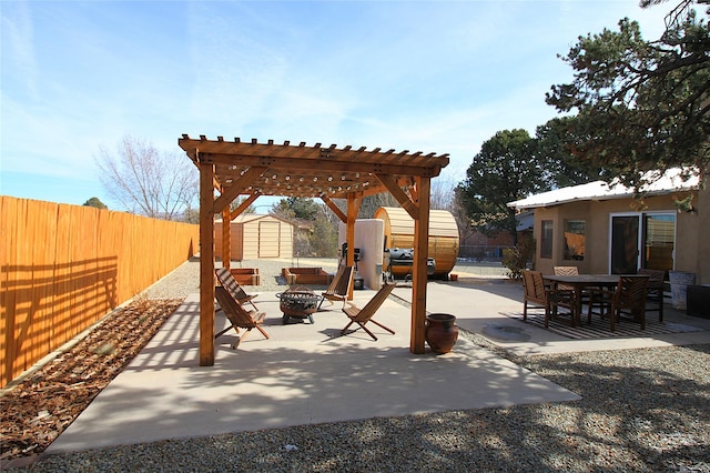 view of jungle gym featuring an outdoor fire pit, a pergola, a patio area, and a storage shed