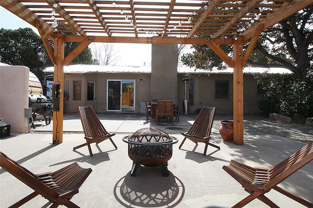 view of patio featuring a pergola, a grill, and an outdoor fire pit